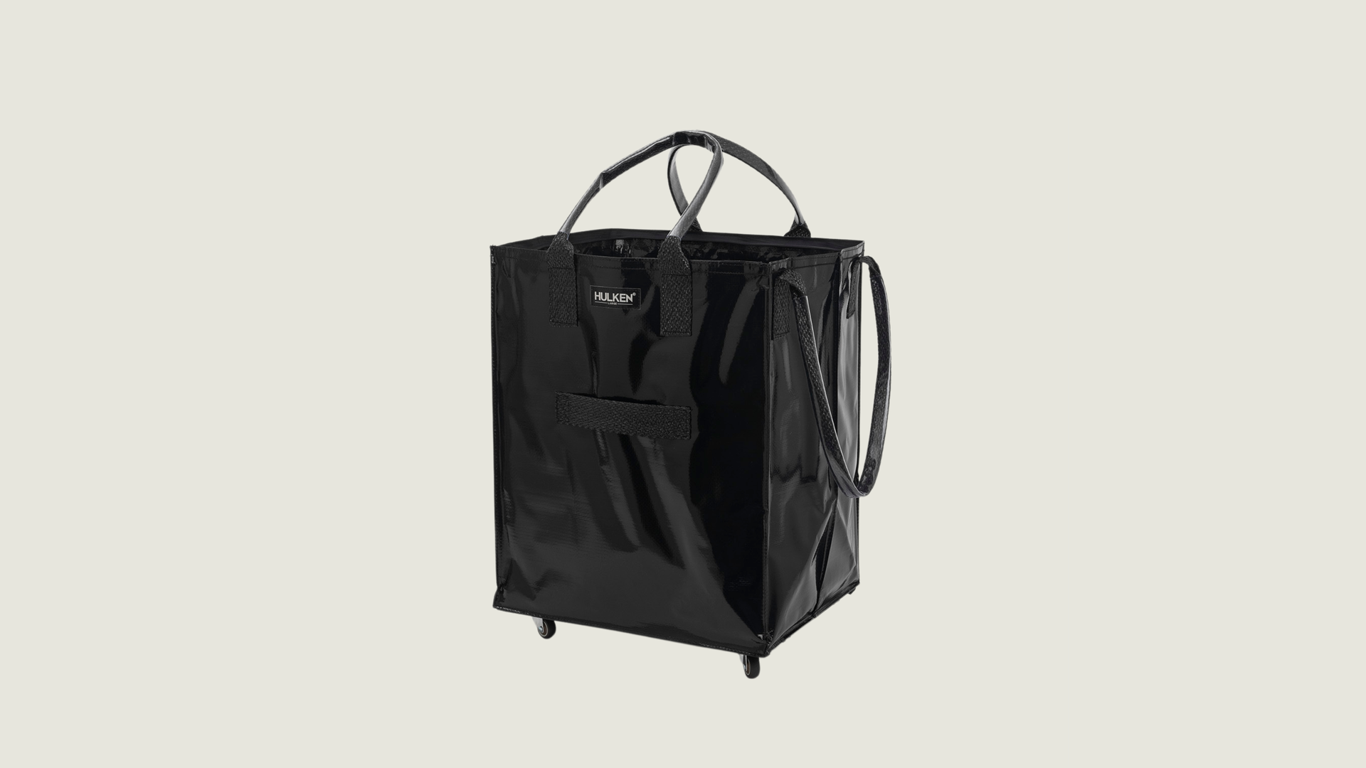 Black tote bag with a brand logo on a light gray background