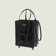 Black rolling laundry bag with wheels on a beige background