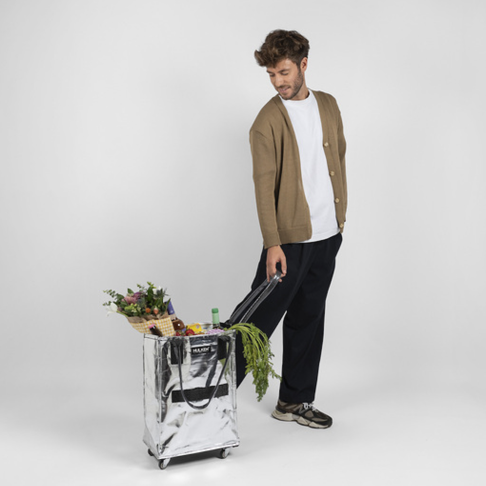 A man with silver HULKEN tote bag
